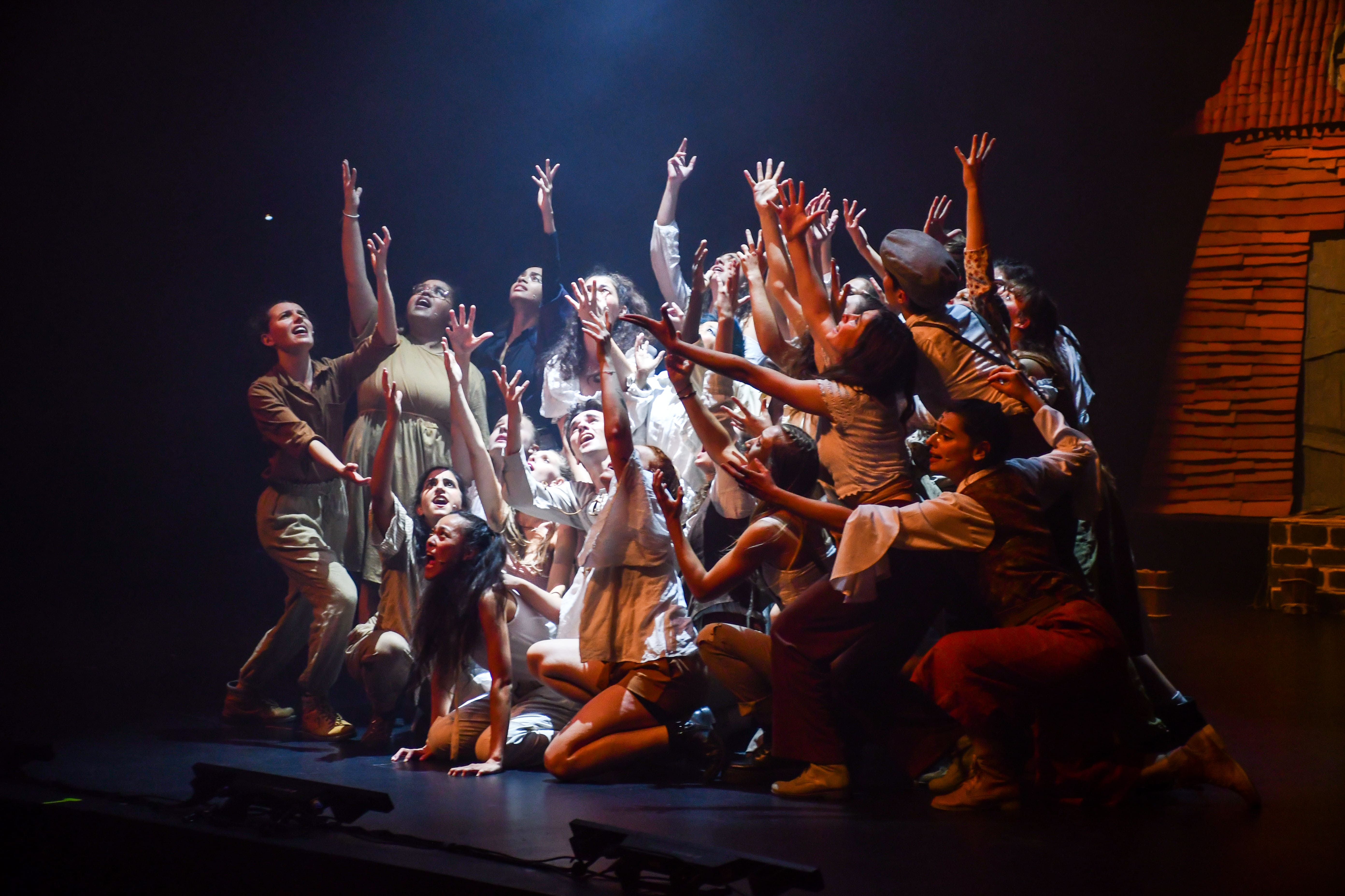 Troupe entre ombre et lumière levant les bras au ciel